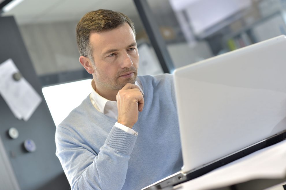 Industrial manager in office working on laptop