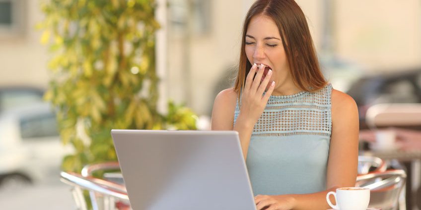 Woman yawning and working in a restaurant during breakfast