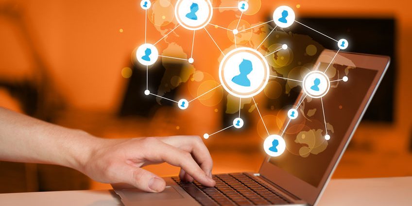 Close up of hand with laptop and social media icons
