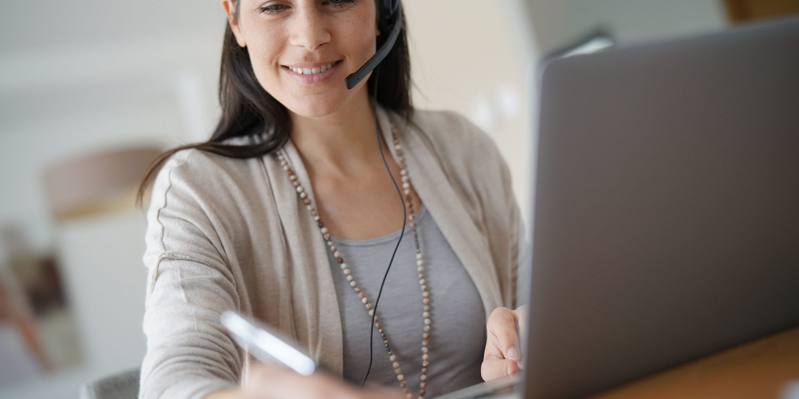 Home-office teleoperator talking on phone with headset