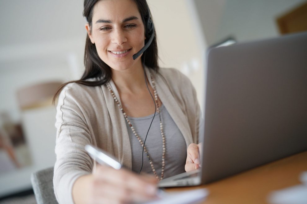 Home-office teleoperator talking on phone with headset