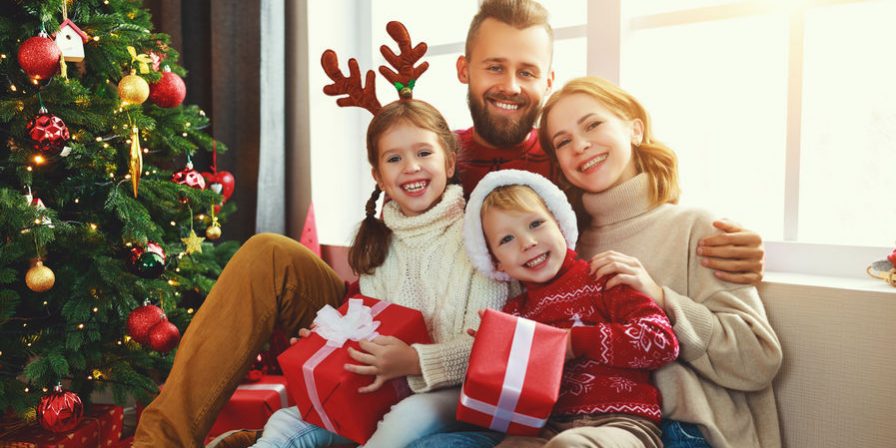 happy family with gifts near   Christmas tree at home