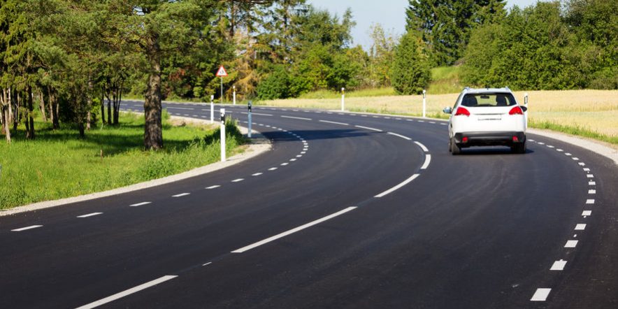 Car on asphalt road in beautiful spring day