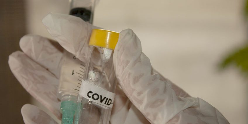 Gloved hand with medical tools for vaccination