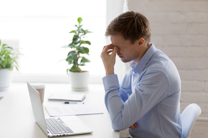 Tired businessman massaging nose bridge, feeling eyes strain