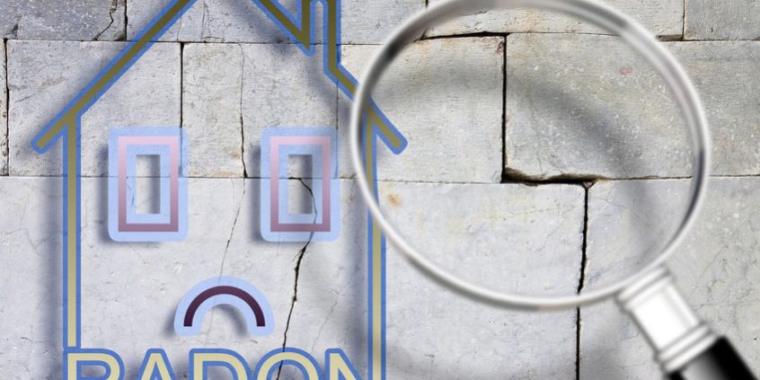 The danger of radon gas in our homes – concept image with an outline of a small house with radon text against a cracked stone wall with a magnifying glass