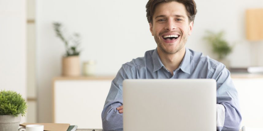 Positive Guy Laughing Looking At Camera Sitting At Laptop Indoor