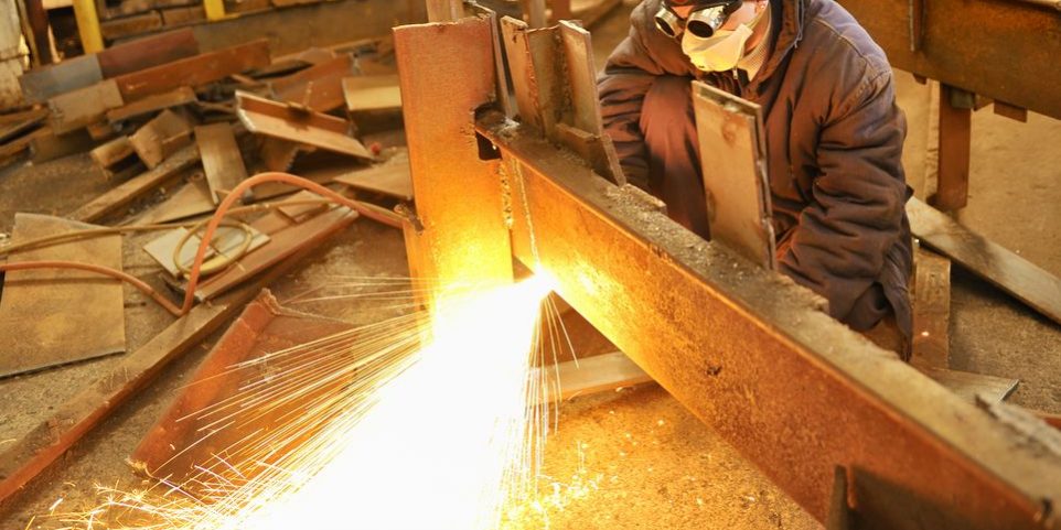 16475828 – worker using torch cutter to cut through metal