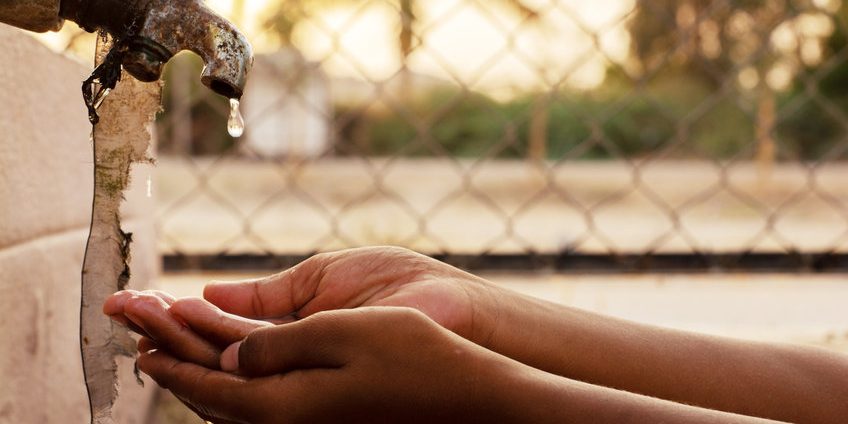 Closeup of hands, child drinking water directly from corporation tap water in India