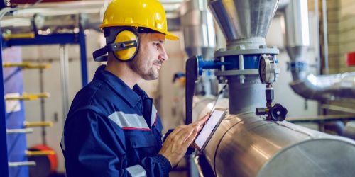 Side,View,Of,Dedicated,Factory,Worker,Standing,Next,To,Boiler