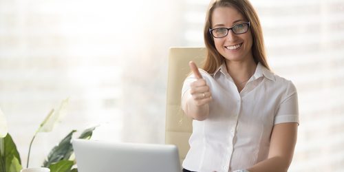 Attractive,Businesswoman,Looking,At,Camera,,Showing,Thumbs,Up,At,Workplace,